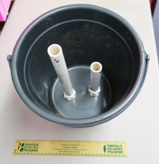 Figure 3. Completed Modified Sweatless Soil Sampler with single exit hole in the PVC pipes. This model has two sampling tubes installed, one for a 4-inch sampling depth, and another for an 8-inch sampling depth. Note the conduit nuts on the bottom of the pail holding the male adapters in place. Photo credit: W. Bryan Smith, Clemson University.