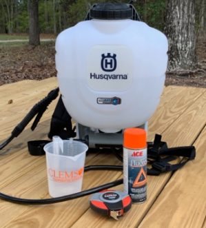a backpack sprayer with measuring container, measuring tape, and spray paint
