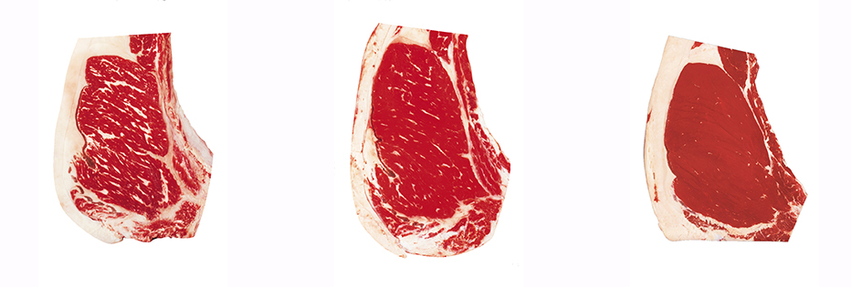 Three raw cuts of beef ribeye steaks with different marbling.
